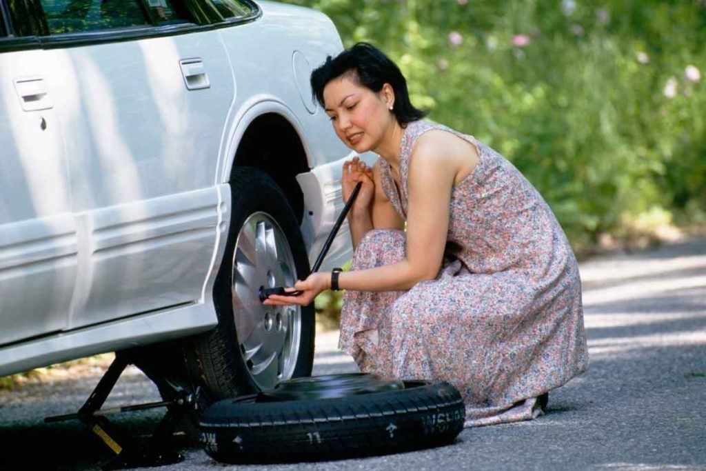 Woman is changing a flat tire 